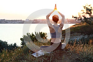 Young woman  yoga outdoors on sunset. Zen meditation