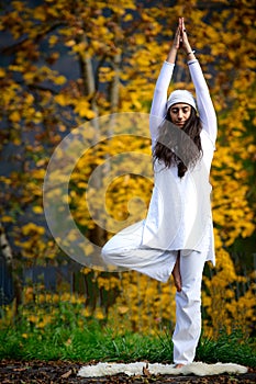 Young woman during a yoga practice in the autumn nature photo