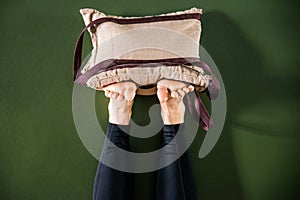 Young woman in yoga relaxing pose with legs up against wall with heavy sand bags