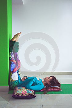 Young woman in yoga relaxing pose with legs up the wall