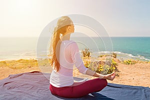 Young woman yoga on the sea beach