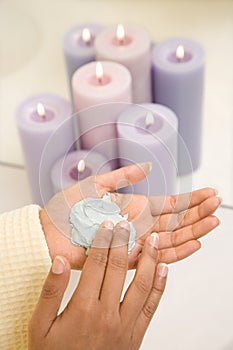 Young womans hands with facial scrub.