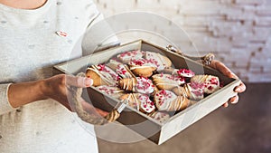 Young womans hands hold big box with hommade cookies hearts. Present for Valentines day