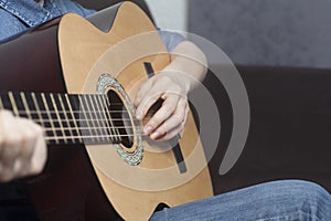 Young womans hands playing a acoustic classic guitar