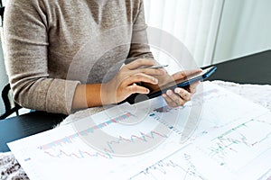 Young women analyze stock graph and report, set targets for online trading management success