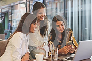 Young women in cafe. Using smart phone.