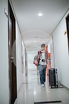 young women carrying bags and suitcases walk in the hotel hallway