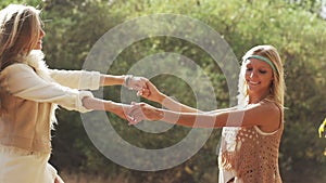 Young women dancing laughing spinning around