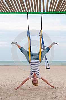 Young women doing aerial yoga asanas or antigravity Yoga indoor. Flying, fitness, stretch, balance, exercise and healthy