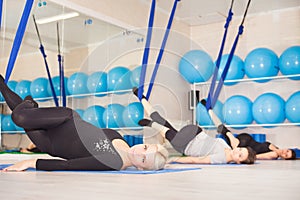 Young women doing aerial yoga exercise or antigravity yoga