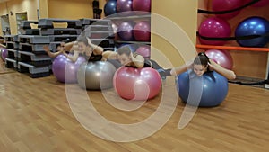 Young women doing exercise with balls.