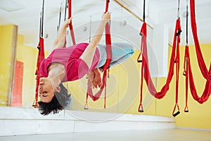 Young women doing yoga exercise or aerial yoga antigravity in the studio.