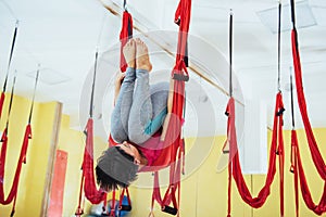 Young women doing yoga exercise or aerial yoga antigravity in the studio.