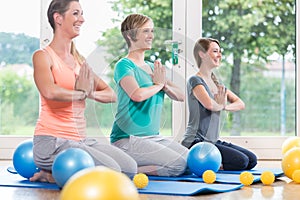 Young women doing yoga during postnatal recovery lesson