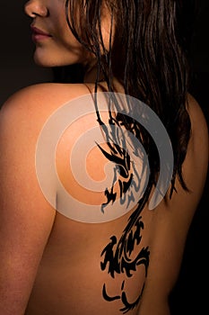 Young women with a dragon tattoo on her back