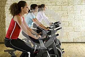 Young women on exercise bikes