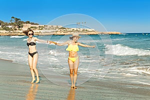 Young women friends having fun on the beach, sea tropical vacation