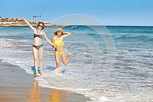 Young women friends having fun on the beach, sea tropical vacation