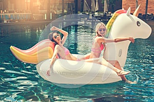 Young women friends in the swimming pool fun