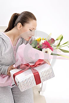 Young women with gift and flowers