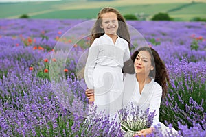 Young woman and girl are in the lavender field, beautiful summer landscape with red poppy flowers