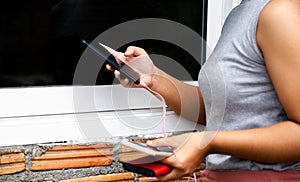 Young women hands holding and playing smartphone While charging the smartphone battery and device Charge Sharing