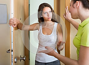 Young women having conflict at the door