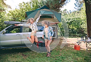 Young women having fun in campsite with 4x4 on