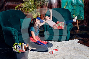 A young woman and her daughter are tiredly sitting on the floor after spring cleaning photo