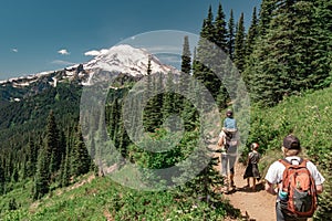 Young women hiking with kids toward Mt Rainier on the Naches Peak Loop Trail in Mt. Rainier National Park