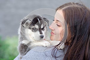 Young women holds her best friend little pet puppy of husky in her arms. love for dogs