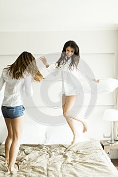 Young women jumping in the bed