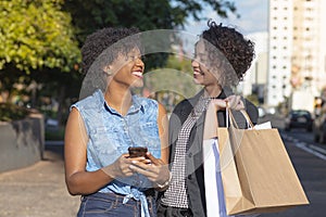 Young women laughing during shopping in the city
