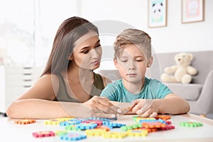 Young woman and little boy with autistic disorder playing photo