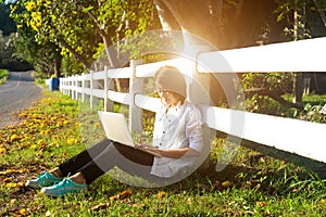 Young women lying in summer grass playing laptop and relax, sunny day,