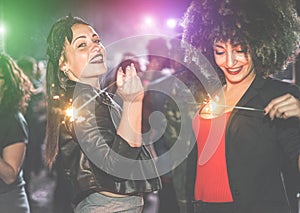 Young women making party with fireworks inside night club - Trendy fashion girls having fun on dance floor - Youth and enjying