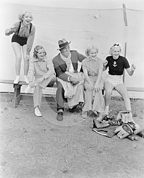 Young women and a man watching a baseball game with enthusiasm photo