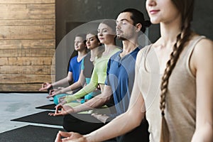 Young women and men in yoga class, relax meditation pose