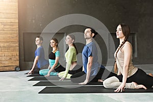 Young women and men in yoga class, relax meditation pose