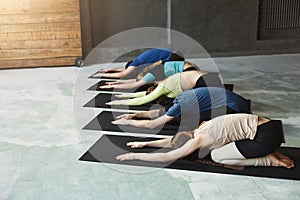 Young women and men in yoga class, relax meditation pose