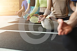 Young women and men in yoga class, relax meditation pose