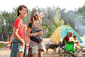 Young women near camping tent