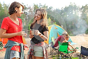 Young women near camping tent