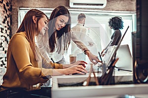 Young women in office working together on desktop