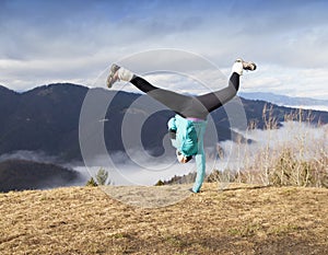 Young women performing one handed cartwheel