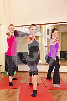 Young women performing stretching exercises in gym