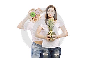 Young women with pineapple and cakes in their hands, a difficult choice. Isolated on white background