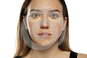 Young women posing with concealer under her eyes and face