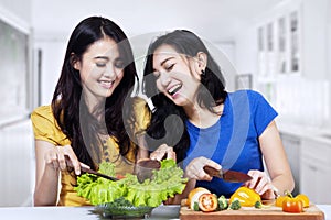 Young women prepare salad together