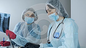 Young women professional laboratory scientist specialists working in modern clinical laboratory discussing medical